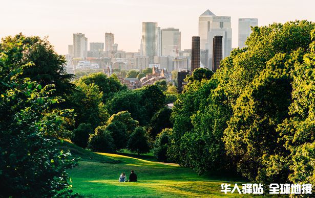 0_A-couple-sit-in-Greenwich-Park-London-looking-the-Canary-Wharf-skyline-stock-photo.jpg